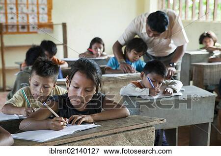 Stock Photo - Schoolchildren learning to write in an elementary school in a village with no road access in the rainforest of the Oriente, Curaray, Ecuador, South America. Fotosearch