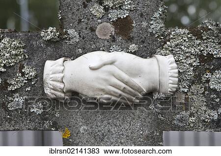 Stock Image - Sculptured handshake on a weathered grave stone, Mora, Dalarna, Sweden, Europe. Fotosearch