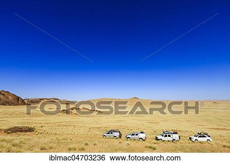 Stock Photograph - Several off-road vehicles in Hartmann Valley, Kunene region, Namibia, Africa. Fotosearch