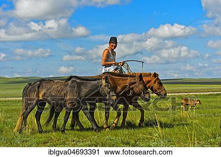 Stock Image - Shepherd rides with horses in the steppe, Mongolia, Asia. Fotosearch