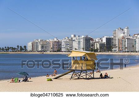 Stock Photography - Swimmers at the city beach, lifeguard tower and skyscrapers in Montevideo, Uruguay, South America. Fotosearch