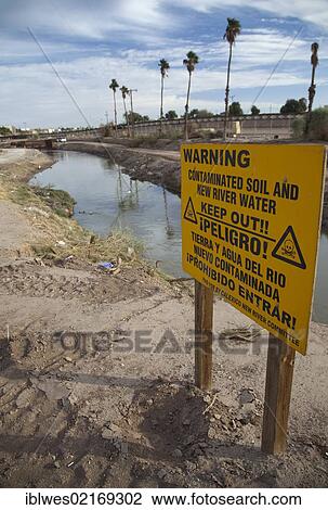 Stock Image - The heavily-polluted New River, as it enters the USA from Mexico; the pollution results from a mix of untreated sewage, agricultural runoff, and industrial waste, Calexico, California, USA, North America. Fotosearch