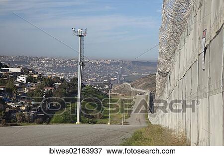 The international border between the United States and Mexico; the tower on the left side of the road holds cameras for day and night surveillance, the Border Patrol's new fence at right and Tijuana on the left, San Ysidro, California, USA, North America View Large Photo Image Stock Photo - The international border between the United States and Mexico; the tower on the left side of the road holds cameras for day and night surveillance, the Border Patrol's new fence at right and Tijuana on the left, San Ysidro, California, USA, North America. Fotosearch