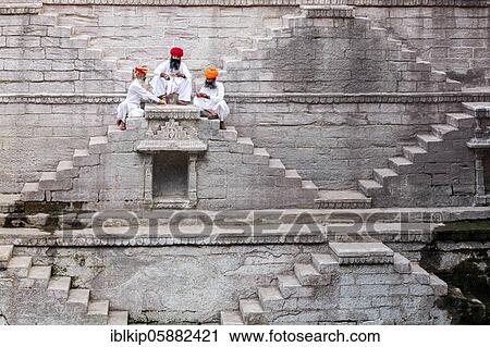 Stock Image - Three men playing cards at the stepwell Toorji Ka Jhalra, Jodhpur, Rajasthan, India, Asia. Fotosearch