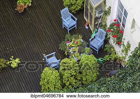 Top view of outdoor terrace of apartment building with plants and wooden sitting chairs in late summer, Tallinn, Estonia, Europe View Large Photo Image Picture - Top view of outdoor terrace of apartment building with plants and wooden sitting chairs in late summer, Tallinn, Estonia, Europe. Fotosearch