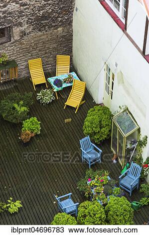 Top view of outdoor terrace of apartment building with plants and wooden sitting chairs in late summer, Tallinn, Estonia, Europe View Large Photo Image Stock Image - Top view of outdoor terrace of apartment building with plants and wooden sitting chairs in late summer, Tallinn, Estonia, Europe. Fotosearch