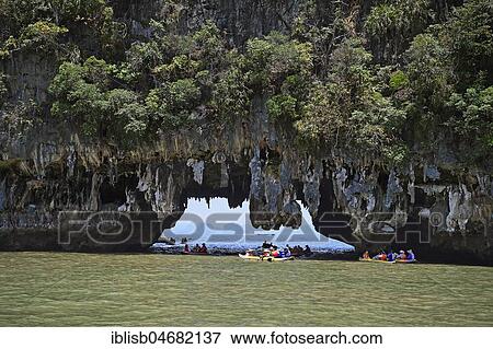 Stock Photo - Tourists exploring eroded limestone rocks with canoes in Phang Nga Bay, Ao Phang Nga Marine National Park, Thailand, Asia. Fotosearch