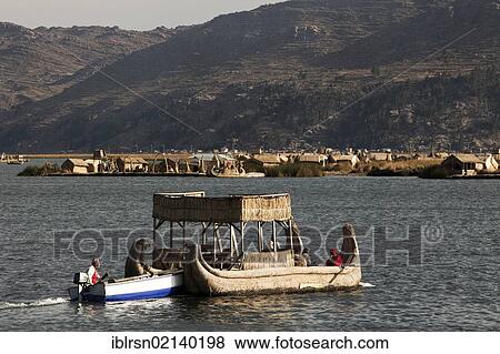 Traditional reed boat being pushed by a motorized boat, floating islands of the Urus on Lake Titicaca, constructed by the totora reeds growing there, Puno, Peru, South America View Large Photo Image Stock Photo - Traditional reed boat being pushed by a motorized boat, floating islands of the Urus on Lake Titicaca, constructed by the totora reeds growing there, Puno, Peru, South America. Fotosearch