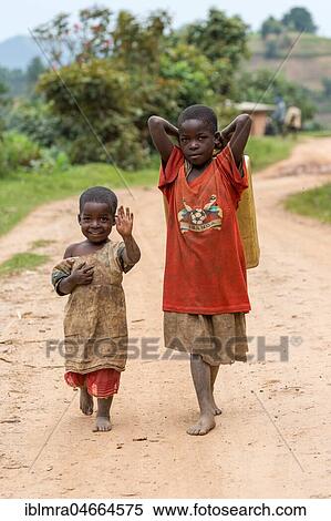 Stock Photography - Two African children on a sandy track, waving, near Lake Mutanda, Uganda, Africa. Fotosearch