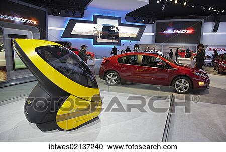Two Chevrolet electric cars on display at the North American International Auto Show; the yellow EN-V pod-like car is a concept; the red Volt is in production, Detroit, Michigan, USA, North America View Large Photo Image Stock Image - Two Chevrolet electric cars on display at the North American International Auto Show; the yellow EN-V pod-like car is a concept; the red Volt is in production, Detroit, Michigan, USA, North America. Fotosearch