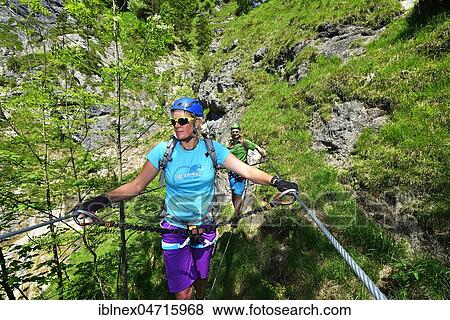 Stock Photo - Two climbers on suspension bridge, via ferrata Hausbachfall, Reit im Winkl, Chiemgau, Bavaria, Germany, Europe. Fotosearch
