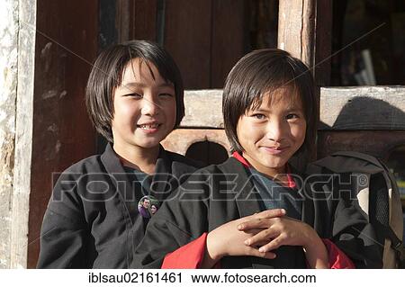 Two smiling girls, portrait, dressed in traditional costume in the village of Thinleygang near Punakha, the Himalayas, Kingdom of Bhutan, South Asia, Asia View Large Photo Image Stock Image - Two smiling girls, portrait, dressed in traditional costume in the village of Thinleygang near Punakha, the Himalayas, Kingdom of Bhutan, South Asia, Asia. Fotosearch
