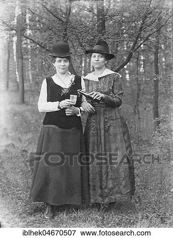 Two women with hat share a beer in the forest, 1920s, Germany, Europe View Large Photo Image Stock Photo - Two women with hat share a beer in the forest, 1920s, Germany, Europe. Fotosearch