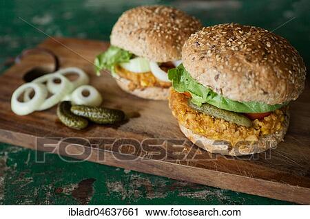 Stock Image - Vegan burgers with corn pattie, pickles and onions, food still-life, studio shot. Fotosearch