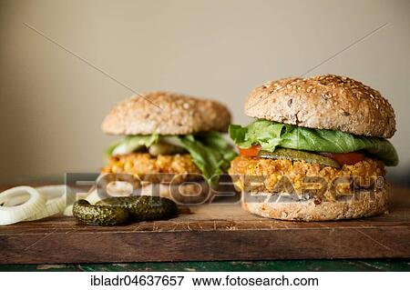 Stock Photo - Vegan burgers with corn pattie, pickles and onions, food still-life, studio shot. Fotosearch