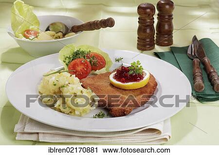 Viennese Schnitzel with lemon and cranberries, potato salad View Large Photo Image Stock Image - Viennese Schnitzel with lemon and cranberries, potato salad. Fotosearch