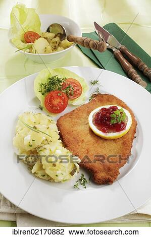 Viennese Schnitzel with lemon and cranberries, potato salad View Large Photo Image Stock Image - Viennese Schnitzel with lemon and cranberries, potato salad. Fotosearch