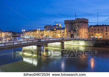 Picture - View of the town, bridge over the Meuse with gate Porte Chaussée, dusk, Verdun, Grand Est, France, Europe. Fotosearch