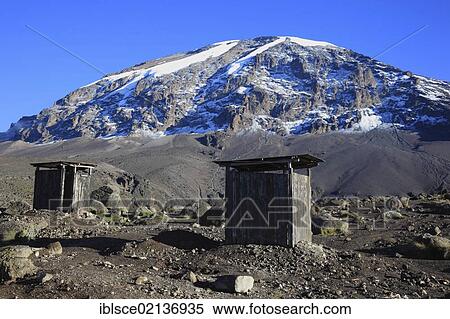 Stock Photography - View to the summit of Mount Kilimanjaro, as seen from the Barranco Hut, with the toilet houses of the Barranco campsite in the foreground, Tanzania, Africa. Fotosearch