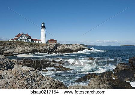 Stock Image - White lighthouse, waves breaking on rocks, Portland Head Light, Portland, Cape Elizabeth, Maine, New England, USA, North America, America, North America. Fotosearch