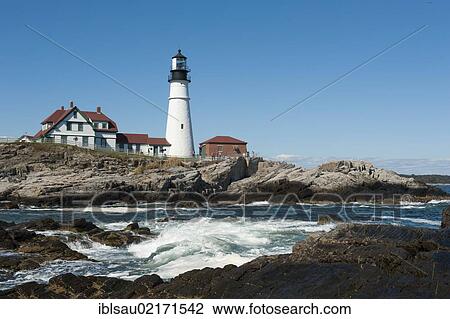 Stock Image - White lighthouse, waves breaking on rocks, Portland Head Light, Portland, Cape Elizabeth, Maine, New England, USA, North America, America, North America. Fotosearch