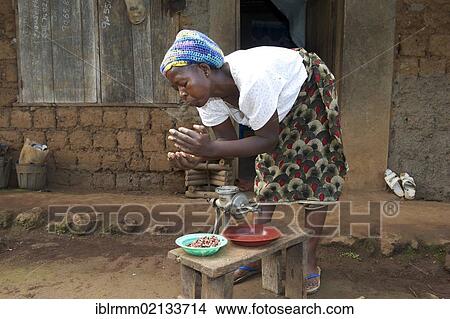 Picture - Woman grinding peanuts, Bamenda, Cameroon, Africa. Fotosearch