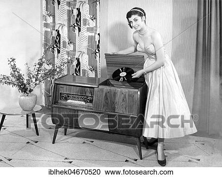Woman in front of a record player in the living room, 1950s, Germany, Europe View Large Photo Image Stock Image - Woman in front of a record player in the living room, 1950s, Germany, Europe. Fotosearch
