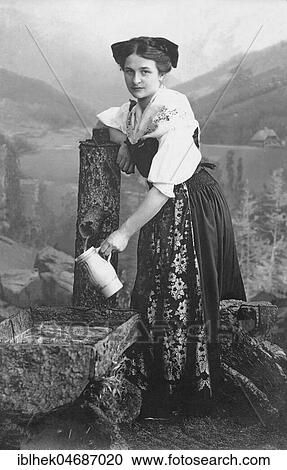 Woman in Traditional Costume Filling a Jug with Water at the Well, 1910s, Germany, Europe View Large Photo Image Stock Image - Woman in Traditional Costume Filling a Jug with Water at the Well, 1910s, Germany, Europe. Fotosearch