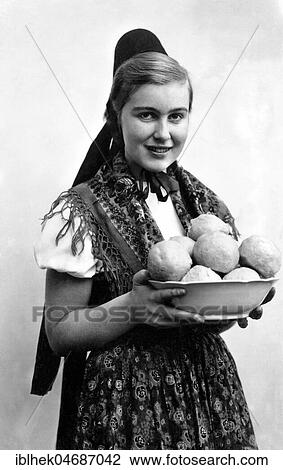 Stock Image - Woman in traditional traditional costume with dumplings, dumplings, 1930s, Germany, Europe. Fotosearch