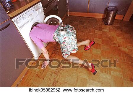 Woman looking for something in the washing machine, Berlin, Germany, Europe View Large Photo Image Stock Image - Woman looking for something in the washing machine, Berlin, Germany, Europe. Fotosearch