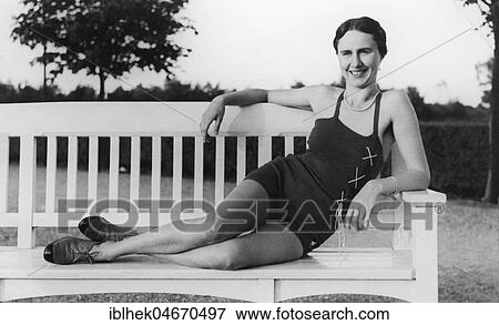 Stock Photo - Woman posing in a bathing suit on a white park bench, 1920s, Germany, Europe. Fotosearch