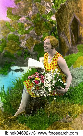 Stock Image - Woman with flowers in a meadow, 1930s, Germany, Europe. Fotosearch