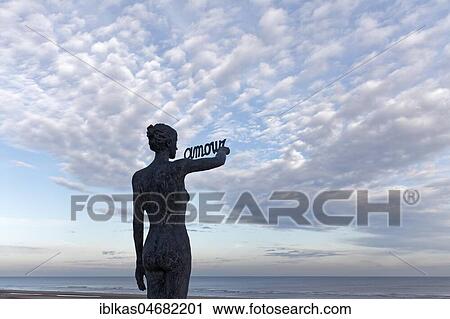 Woman writes French word Amour, Love, in the sky, bronze sculpture by Belgian sculptor Linde Ergo, De Haan, North Sea, Belgian coast, West Flanders, Belgium, Europe View Large Photo Image Stock Image - Woman writes French word Amour, Love, in the sky, bronze sculpture by Belgian sculptor Linde Ergo, De Haan, North Sea, Belgian coast, West Flanders, Belgium, Europe. Fotosearch