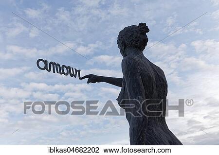 Woman writes French word Amour, Love, in the sky, bronze sculpture by Belgian sculptor Linde Ergo, De Haan, West-Flanders, Belgium, Europe View Large Photo Image Stock Image - Woman writes French word Amour, Love, in the sky, bronze sculpture by Belgian sculptor Linde Ergo, De Haan, West-Flanders, Belgium, Europe. Fotosearch