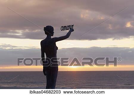 Woman writes French word Amour, Love, in the sky at sunset, bronze sculpture by Belgian sculptor Linde Ergo, De Haan, North Sea, Belgian coast, West Flanders, Belgium, Europe View Large Photo Image Stock Image - Woman writes French word Amour, Love, in the sky at sunset, bronze sculpture by Belgian sculptor Linde Ergo, De Haan, North Sea, Belgian coast, West Flanders, Belgium, Europe. Fotosearch
