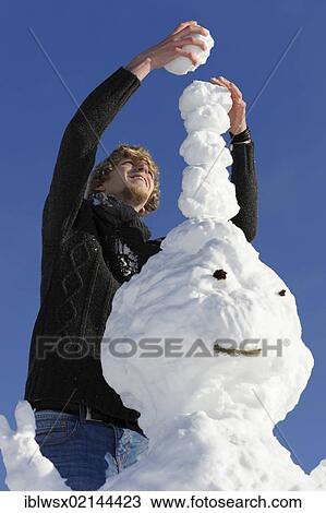 Stock Image - Young man building a snowman, Black Forest, Baden-Wuerttemberg, Germany, Europe, PublicGround, Europe. Fotosearch