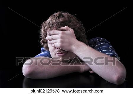Young man covering face with his hand View Large Photo Image Stock Photo - Young man covering face with his hand. Fotosearch