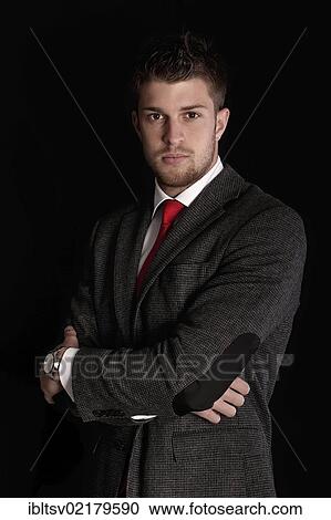 Young man wearing a suit, with arms crossed View Large Photo Image Stock Image - Young man wearing a suit, with arms crossed. Fotosearch