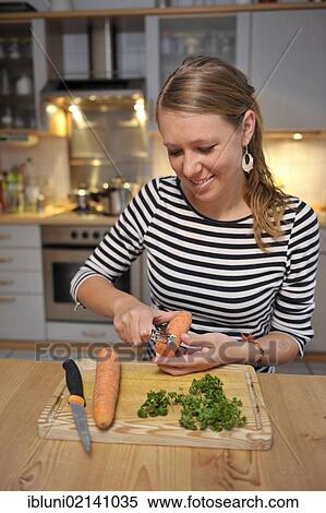Young woman cutting vegetables in a kitchen View Large Photo Image Stock Photography - Young woman cutting vegetables in a kitchen. Fotosearch