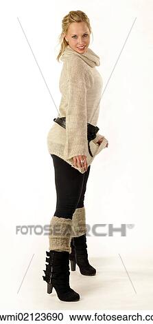 Stock Image - Young woman wearing a knitted sweater and boots. Fotosearch