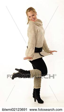 Stock Image - Young woman wearing a knitted sweater and boots. Fotosearch