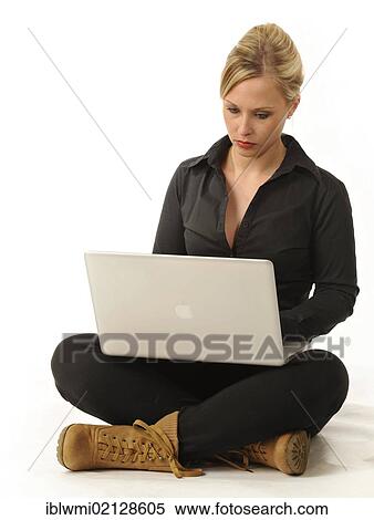 Young woman working on a laptop computer, sitting cross-legged View Large Photo Image Stock Photography - Young woman working on a laptop computer, sitting cross-legged. Fotosearch