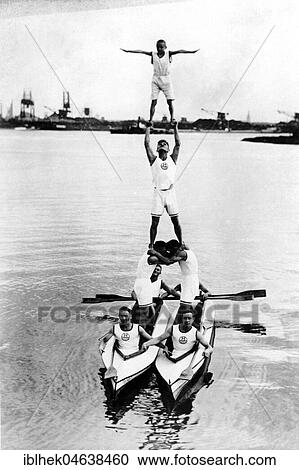 Stock Image - Acrobats build a pyramid on two rowing boats in the water, ca. 1930, 1930s, Hamburg, Germany, Europe. Fotosearch