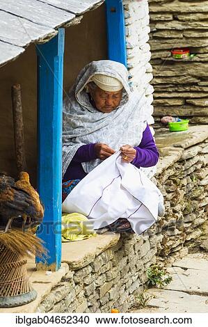 Aged Nepalese woman sitting in the doorway and sewing, Dhampus Mountain village, Nepal, Asia View Large Photo Image Stock Image - Aged Nepalese woman sitting in the doorway and sewing, Dhampus Mountain village, Nepal, Asia. Fotosearch
