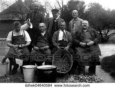 Picture - Agriculture, men peeling potatoes, 1930s, exact place unknown, Germany, Europe. Fotosearch