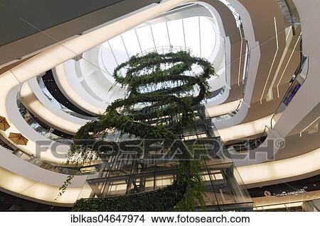 Atrium with green glass elevator, Water Garden in the European Championship quarter, Emporium, Luxury Shopping Mall, Sukhumvit Road, Khlong Toei, Bangkok, Thailand, Asia View Large Photo Image Picture - Atrium with green glass elevator, Water Garden in the European Championship quarter, Emporium, Luxury Shopping Mall, Sukhumvit Road, Khlong Toei, Bangkok, Thailand, Asia. Fotosearch