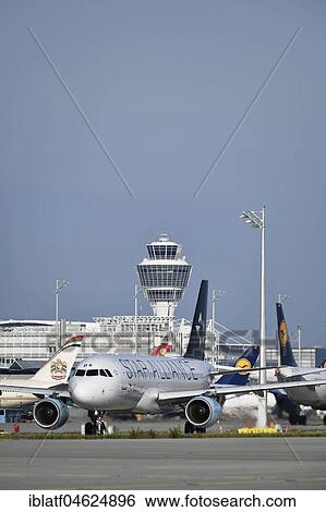 Stock Photograph - Austrian Airlines, Star Alliance, Airbus A320 rolls onto runway with tower in the background, Munich Airport, Upper Bavaria, Germany, Europe. Fotosearch