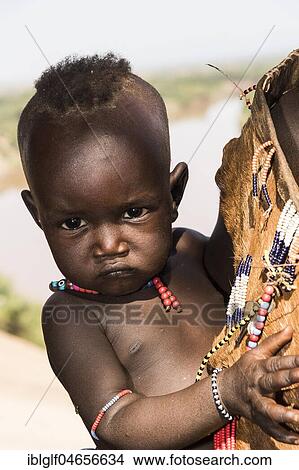 Picture - Baby of the Karo tribe, portrait, behind Omo River, Southern Nations Nationalities and Peoples' Region, Ethiopia, Africa. Fotosearch