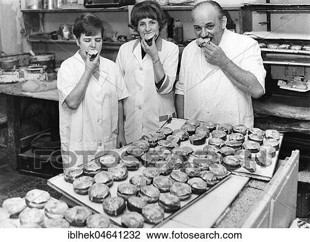 Stock Image - Baker and employees eat pancakes, doughnuts, Berlin, 1960s, Berlin, Germany, Europe. Fotosearch