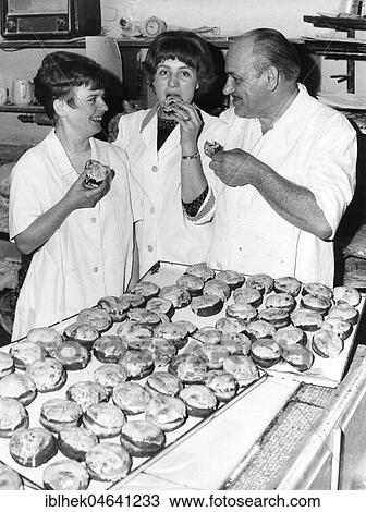 Stock Image - Baker and employees eat pancakes, doughnuts, Berlin, 1960s, Berlin, Germany, Europe. Fotosearch